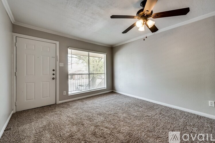A room with a ceiling fan and carpeted floor.