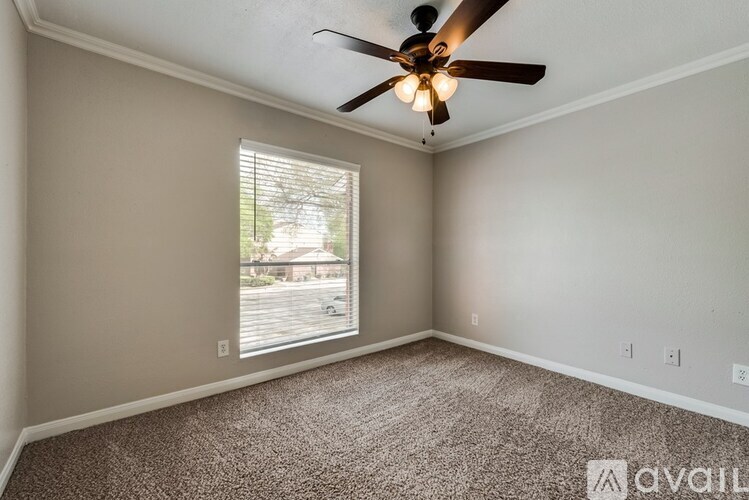 A room with a ceiling fan and a window with blinds.