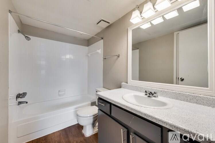 A bathroom with a white tub, sink, and toilet.