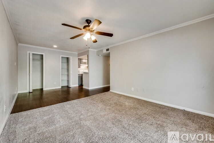 A spacious room with a ceiling fan and carpeted floor.