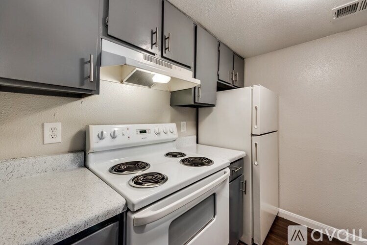 A kitchen with a white stove and a white refrigerator.