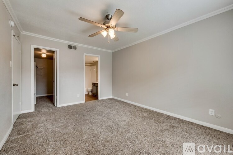 A room with a ceiling fan and carpeted floor.