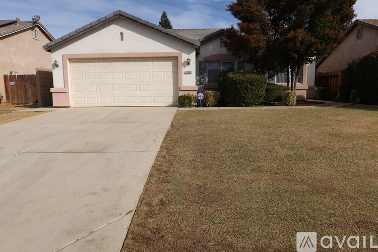 A house with a garage and a driveway in front of it.