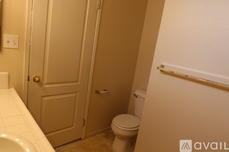 A bathroom with a toilet, sink, and a door.