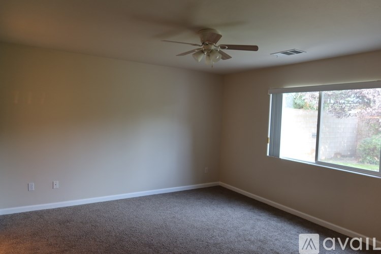 A room with a ceiling fan and a window.