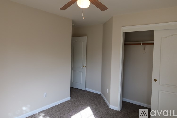 A room with a ceiling fan and two doors.