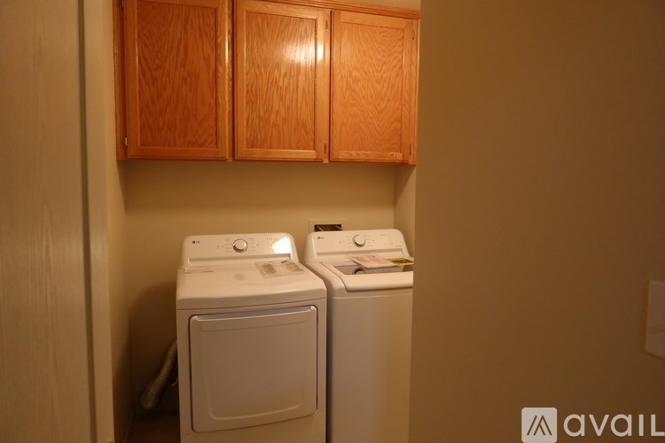 Two white washing machines in a small laundry room.