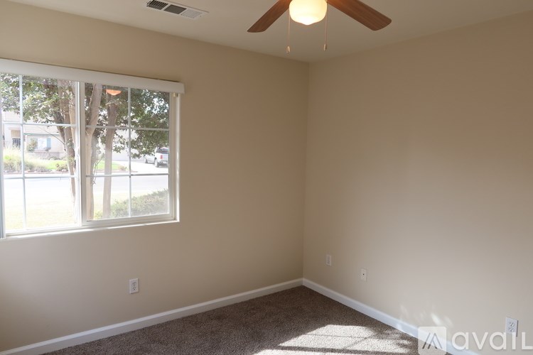 A room with a window and a ceiling fan.
