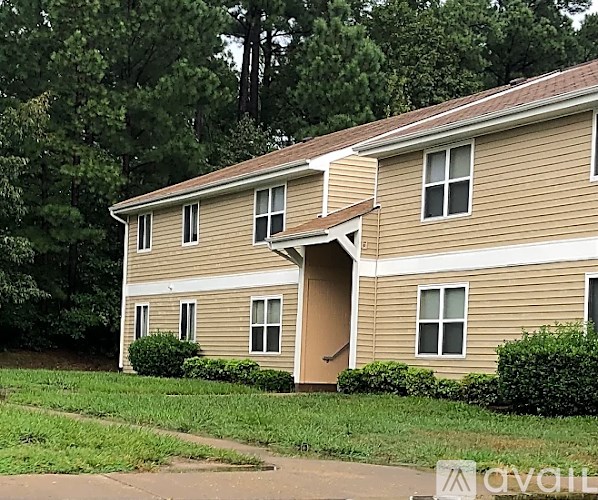 A beige house with a brown roof and a brown door.