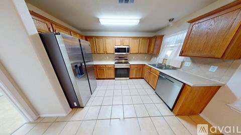 A kitchen with wooden cabinets and a refrigerator.