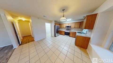 A kitchen with wooden cabinets and a tiled floor.