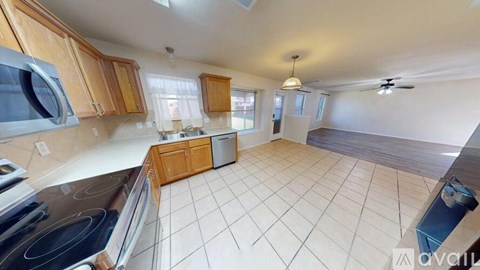 A kitchen with wooden cabinets and a white tile floor.