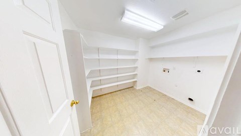 A white room with a door and a wooden floor.