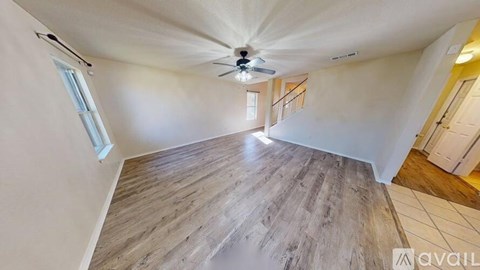 A room with a wooden floor and a ceiling fan.