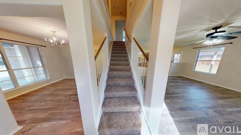 A spacious hallway with a staircase leading to the upper floor.