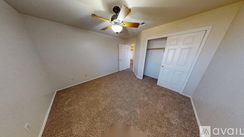 A room with a carpeted floor and a ceiling fan.