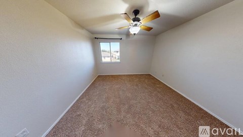 A room with a ceiling fan and a window.