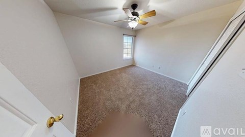 A room with a carpeted floor and a ceiling fan.
