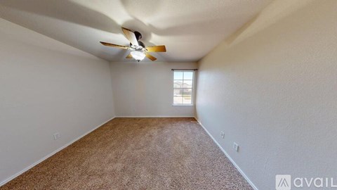A room with a ceiling fan and carpeted floor.