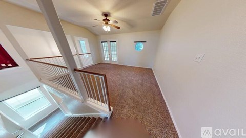 A spacious room with a staircase leading to the upper floor.