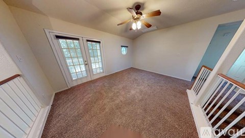 A room with a ceiling fan and a carpeted floor.