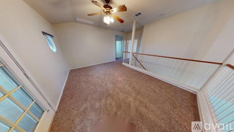 A living room with a carpeted floor and a ceiling fan.