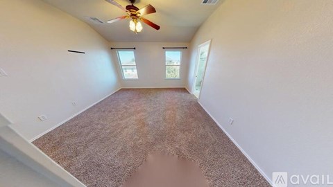 A room with a ceiling fan and carpeted floor.