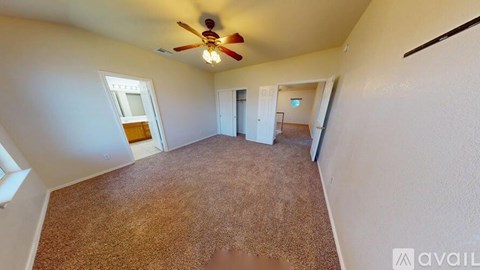 A room with a carpeted floor and a ceiling fan.