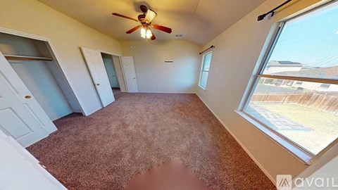 A room with a carpeted floor and a ceiling fan.