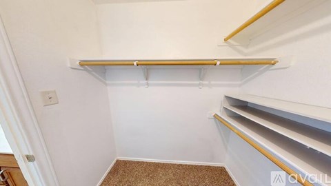 A white wall with a brown carpet and a white shelf above it.