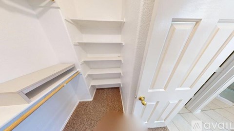 A white door with a gold handle is in the center of a hallway.