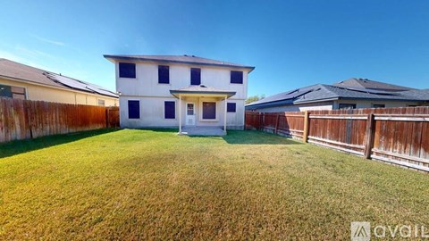 A white house with a brown fence in the front yard.