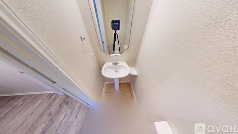 A bathroom with a toilet and a camera on a tripod.