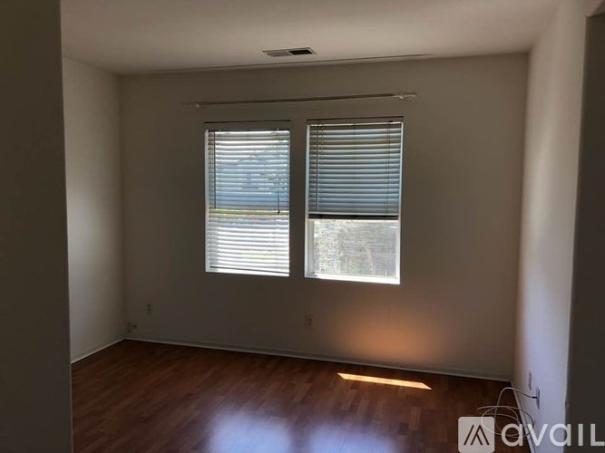A room with a window covered by white blinds.