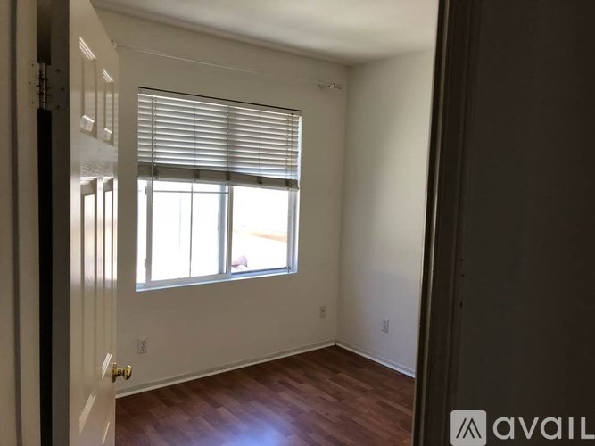 A room with a window and wooden flooring.