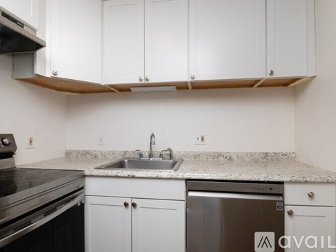 A kitchen with white cabinets and a granite countertop.