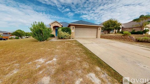 A house with a blue door and a garage is surrounded by a grassy area.