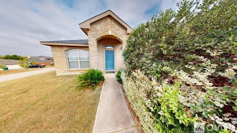 A house with a blue door and a green lawn.