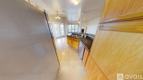 A kitchen with wooden cabinets and a refrigerator.