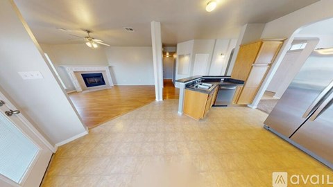 A spacious kitchen with wooden cabinets and a stainless steel refrigerator.