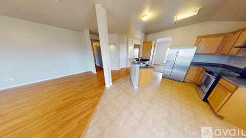 A kitchen with wooden floors and stainless steel appliances.
