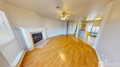 A spacious living room with a fireplace and hardwood floors.
