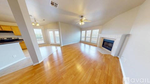 A spacious living room with hardwood floors and a fireplace.