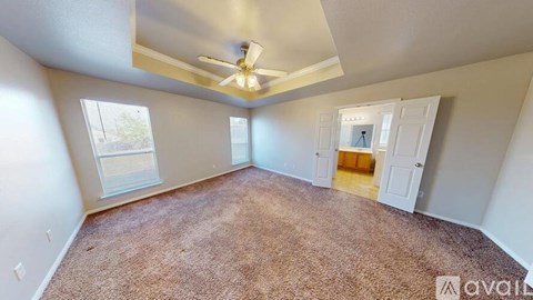 A room with a carpeted floor and a ceiling fan.