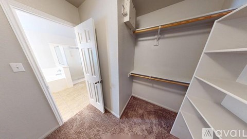 A room with a carpeted floor and a white door.