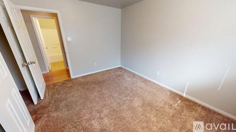 A room with a carpeted floor and a door on the left side.