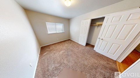 A room with a brown carpet and a white door.