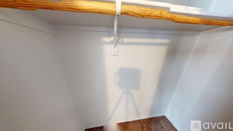 A room with a white wall and a wooden beam on the ceiling.