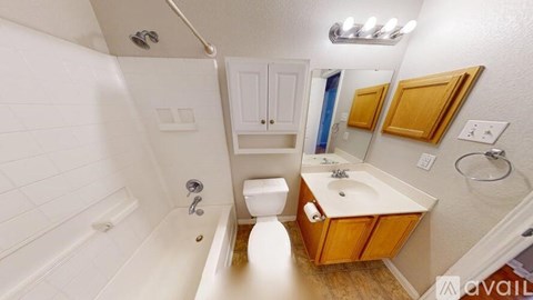A bathroom with a white tub, toilet, and sink.