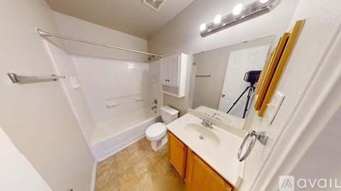 A bathroom with a toilet, sink, and mirror.